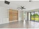 Open living room with lots of natural light, built-in shelving, a wood accent wall, and access to the outdoors at 204 Bella Cortina Dr, Poinciana, FL 34759