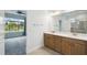 Bright bathroom featuring double sinks, a large mirror, and a separate shower area at 204 Bella Cortina Dr, Poinciana, FL 34759
