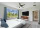 Serene main bedroom offers a large window with views, a modern dresser, and an en-suite bathroom at 204 Bella Cortina Dr, Poinciana, FL 34759
