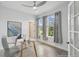 Bright office features a glass desk, ceiling fan, and natural light from two windows at 204 Bella Cortina Dr, Poinciana, FL 34759