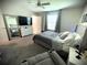 Bright bedroom with gray walls, plush carpet, a queen-size bed, a ceiling fan, and a large framed mirror at 4871 Coral Castle Dr, Kissimmee, FL 34746