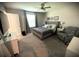 Bright bedroom with gray walls, plush carpet, a queen-size bed, a ceiling fan, and a comfy gray armchair at 4871 Coral Castle Dr, Kissimmee, FL 34746