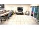 Spacious dining room featuring tile flooring, a large dining table, and a cozy living area at 4871 Coral Castle Dr, Kissimmee, FL 34746