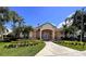 Charming home with a well-manicured lawn, lush landscaping, palm trees, and a tile roof at 4871 Coral Castle Dr, Kissimmee, FL 34746