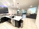 Modern kitchen with dark cabinetry, white countertops, stainless steel appliances, and open to living area at 4871 Coral Castle Dr, Kissimmee, FL 34746