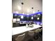 Modern kitchen features dark cabinets, white countertop island with seating and blue accent lighting at 4871 Coral Castle Dr, Kissimmee, FL 34746