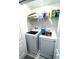 A compact laundry room with a stacked washer and dryer, and a wire shelf for storage at 4871 Coral Castle Dr, Kissimmee, FL 34746