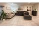 Bright living room featuring neutral furniture, tiled floors, and decorative guitars on the wall at 4871 Coral Castle Dr, Kissimmee, FL 34746