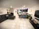Spacious open-concept living area with modern furnishings, dining table, and kitchen in the background at 4871 Coral Castle Dr, Kissimmee, FL 34746