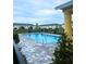 Community pool area with paving stones and wrought iron fence in front of condo building at 4871 Coral Castle Dr, Kissimmee, FL 34746