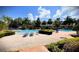 A large community pool surrounded by lounge chairs and beautifully manicured shrubbery at 4871 Coral Castle Dr, Kissimmee, FL 34746