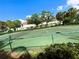 Well-maintained tennis court with a net, surrounded by lush greenery at 4871 Coral Castle Dr, Kissimmee, FL 34746