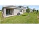 Backyard view of the home with a small tree in the grass at 6385 Clover St, Lake Hamilton, FL 33851