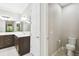 Well-lit bathroom with a modern vanity, a toilet, and a large mirror that reflects the shower at 789 Cielo Trl, Kissimmee, FL 34759