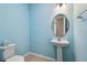 Charming powder room with blue walls, tile floor and pedestal sink at 789 Cielo Trl, Kissimmee, FL 34759