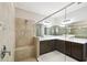 Modern bathroom featuring a spacious walk-in shower with seating, and large mirrors above the vanities at 789 Cielo Trl, Kissimmee, FL 34759