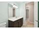 Bright bathroom with a dark vanity, large mirror, and doorways leading to other rooms at 789 Cielo Trl, Kissimmee, FL 34759