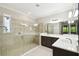 Modern bathroom featuring a spacious walk-in shower with glass door and dual vanities at 789 Cielo Trl, Kissimmee, FL 34759