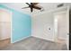 Bright bedroom featuring a ceiling fan, blue accent wall, and doorways to adjoining rooms at 789 Cielo Trl, Kissimmee, FL 34759