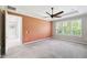Well-lit bedroom features a ceiling fan, neutral carpeting, and a view of the outdoors through the window at 789 Cielo Trl, Kissimmee, FL 34759