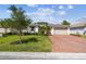 Charming single-story home with lush lawn, mature trees, and a brick driveway on a sunny day at 789 Cielo Trl, Kissimmee, FL 34759