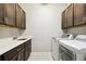 Well-lit laundry room with ample cabinetry, quartz counters and modern machines at 789 Cielo Trl, Kissimmee, FL 34759