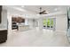 Open-concept living space with a kitchen island, stainless steel appliances, and sliding glass doors to the outdoor patio at 789 Cielo Trl, Kissimmee, FL 34759
