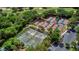 Aerial view of multiple tennis courts surrounded by lush greenery and a parking area at 789 Cielo Trl, Kissimmee, FL 34759
