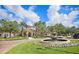 Beautiful clubhouse with a fountain, lush landscaping and a circle drive on a clear, sunny day at 8296 Portofino Dr # 401, Davenport, FL 33896