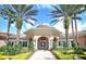Beautiful clubhouse with lush landscaping and tall palm trees on a clear, sunny day at 8296 Portofino Dr # 401, Davenport, FL 33896