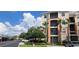 Low angle exterior showcasing the building's architecture, palm trees, and well-maintained landscaping on a sunny day at 8296 Portofino Dr # 401, Davenport, FL 33896