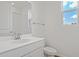 Bright bathroom with a white vanity, toilet, shower, and window for natural light at 1654 Sugarbelle Cir, Mascotte, FL 34753