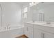 Bright bathroom featuring a double vanity, soaking tub, wood look tile floor, and a separate shower at 1654 Sugarbelle Cir, Mascotte, FL 34753