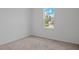 Cozy bedroom featuring neutral carpet, white walls, and a window providing natural light at 1654 Sugarbelle Cir, Mascotte, FL 34753