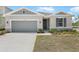 Inviting single-story home with a two-car garage, stone accents, and manicured lawn at 1654 Sugarbelle Cir, Mascotte, FL 34753