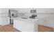 Modern kitchen with stainless steel appliances, white cabinets, a large island, and stylish tile flooring at 1654 Sugarbelle Cir, Mascotte, FL 34753