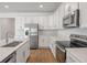 Contemporary kitchen with stainless steel appliances, white cabinets, quartz countertops, and tile flooring at 1654 Sugarbelle Cir, Mascotte, FL 34753