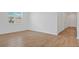 Bright living room featuring wood-look tile flooring, white walls, and natural light from a large window at 1654 Sugarbelle Cir, Mascotte, FL 34753