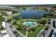 Aerial view featuring community pool, a lake with fountains, green landscaping, and parking area at 3301 Whitestone Cir # 203, Kissimmee, FL 34741