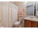 Cozy bathroom featuring a shower with curtain, toilet, and vanity with sink and traditional wood cabinets at 3301 Whitestone Cir # 203, Kissimmee, FL 34741