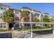 Exterior of a condominium building featuring a covered parking area and well maintained landscaping at 3301 Whitestone Cir # 203, Kissimmee, FL 34741