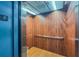 Interior of elevator featuring wood paneling, silver handrail, and bright lighting at 3301 Whitestone Cir # 203, Kissimmee, FL 34741