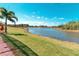Scenic backyard view featuring a lush lawn and serene lake, perfect for outdoor relaxation at 363 Bella Cortina Dr, Kissimmee, FL 34759