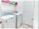 Laundry room with washer, dryer, storage shelf, and a white door at 363 Bella Cortina Dr, Kissimmee, FL 34759