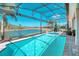 Screened in pool with waterfront views and tropical landscaping in the backyard at 363 Bella Cortina Dr, Kissimmee, FL 34759