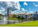 Community water feature with a fountain in a pond next to a building with a tower under cloudy skies at 363 Bella Cortina Dr, Kissimmee, FL 34759