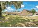 View of the home's backyard with a detached garage and trees at 7938 Riffle Ln, Orlando, FL 32818