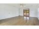Spacious room with neutral walls, ceiling fan, light-colored hardwood floors, and doors to a porch at 7938 Riffle Ln, Orlando, FL 32818