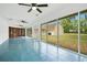Bright sunroom with sliding doors, ceiling fans, and a blue tiled floor, with a view of backyard at 7938 Riffle Ln, Orlando, FL 32818