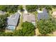 An aerial view showcases a home with a screened pool, situated near water and lush greenery at 9509 Baycliff Ct, Orlando, FL 32836
